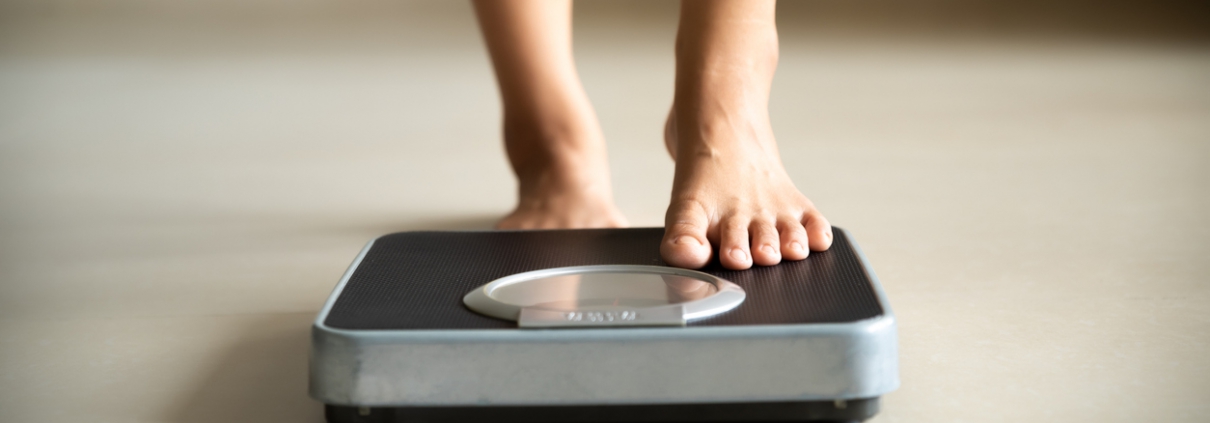 Female leg stepping on weigh scales. Healthy lifestyle, food and sport concept.