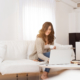 woman using her laptop holding a cup