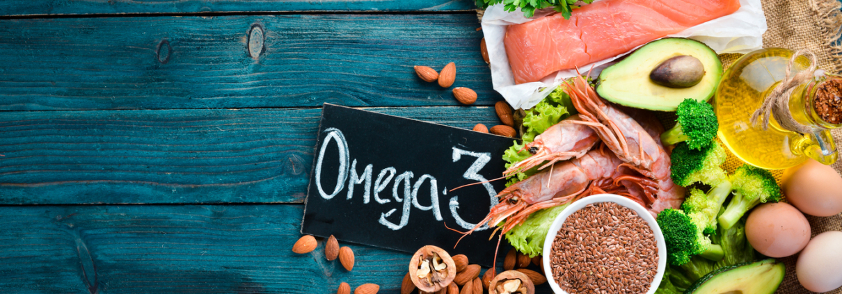 Foods containing omega 3. Vitamin Healthy foods: avocados, fish, shrimp, broccoli, flax, nuts, eggs, parsley. Top view. Free space for your text. On a blue wooden background.