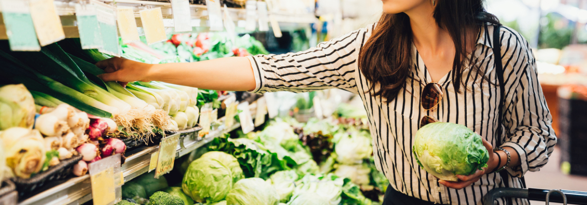 asian local woman buy vegetables and fruits in supermarket. young chinese lady holding green leaf vegetable and picking choosing green onion on cold open refrigerator. elegant female grocery shopping