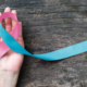 Hand holding a pink ribbon for pregnancy loss awareness