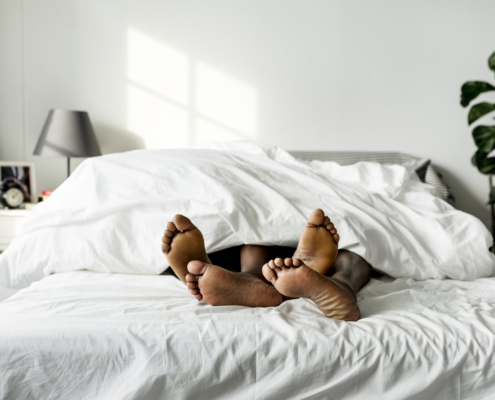 pair of feet sticking out of a bed