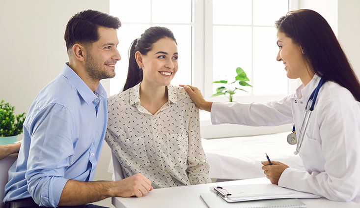 A female doctor consulting a couple for IVF treatment.