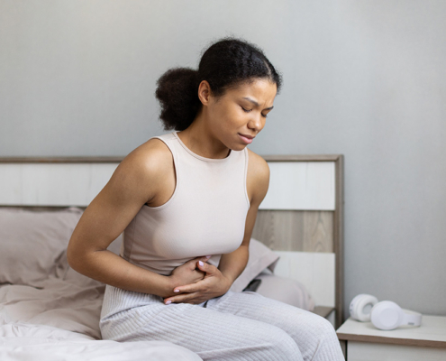 Woman in bed with abdominal pain