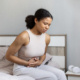 Woman in bed with abdominal pain