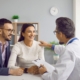 Doctor at desk consulting with young couple about pregnancy planning and fertility treatment options